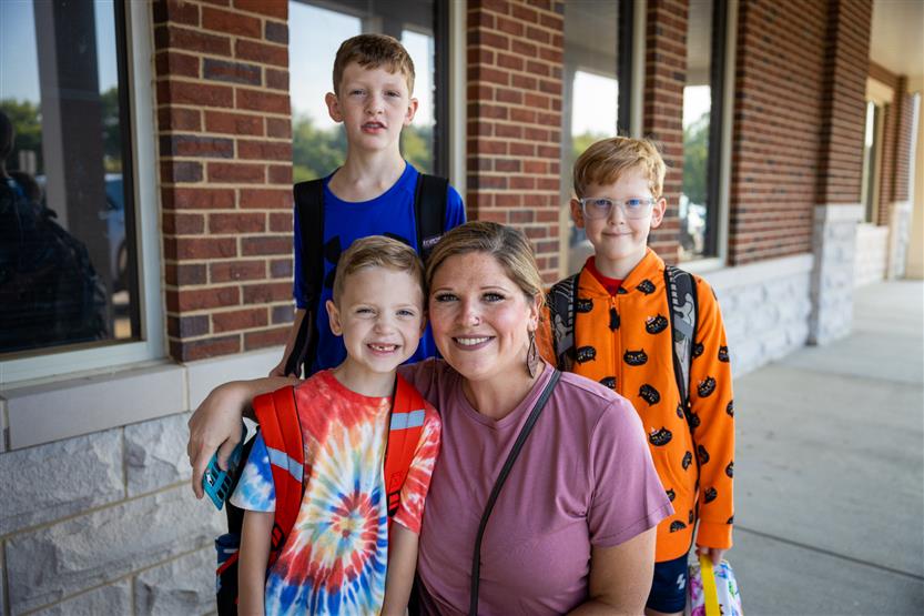 A family smiles on the first full day of kindergarten